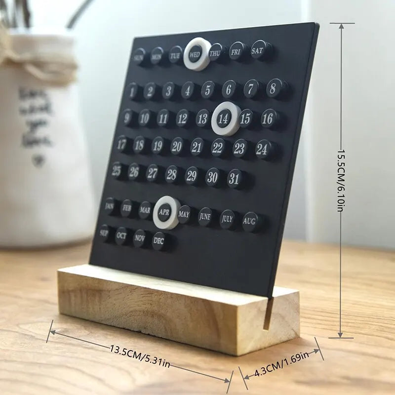 Image of the Callie Calendar, a compact, reusable calendar in black or white with a sleek acrylic design and a natural wooden stand. Features a red marker for highlighting important dates, perfect for organizing spaces like the kitchen or office with a touch of style.