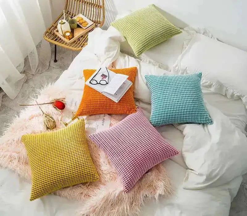 A stylish Warren Pillow Cover displayed on a couch, showcasing its soft corduroy corn grain texture. Available in various colorways and sizes, this square pillow cover adds warmth and elegance to any space. Ideal for home décor enthusiasts, it enhances living areas with a cozy, inviting touch. Please note that the pillow insert is not included.