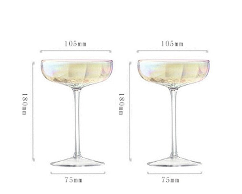 A collection of iridescent glassware from Domus Forge, featuring wine glasses, champagne coupes, decanters, and highball glasses in pastel gradient hues.
