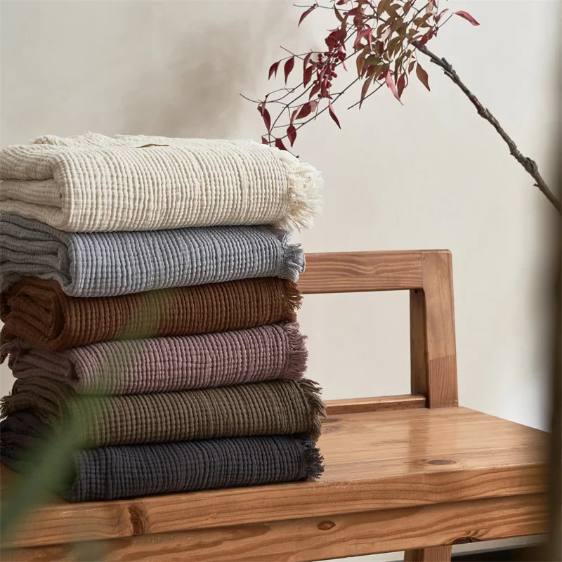 Nogu Throw Blanket – soft Maillard cotton throw with a layered gauze texture, fringe detail, and chic muted colorways, available in two sizes for cozy, stylish comfort.