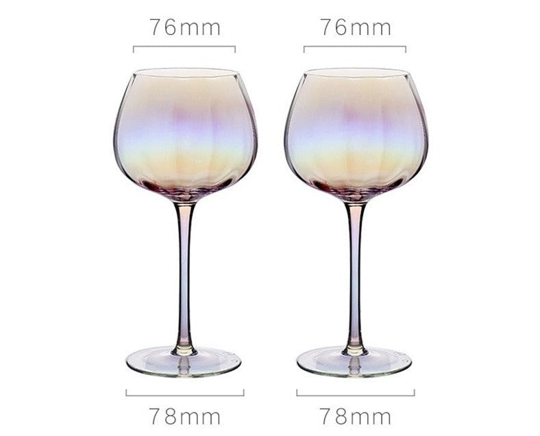 A collection of iridescent glassware from Domus Forge, featuring wine glasses, champagne coupes, decanters, and highball glasses in pastel gradient hues.
