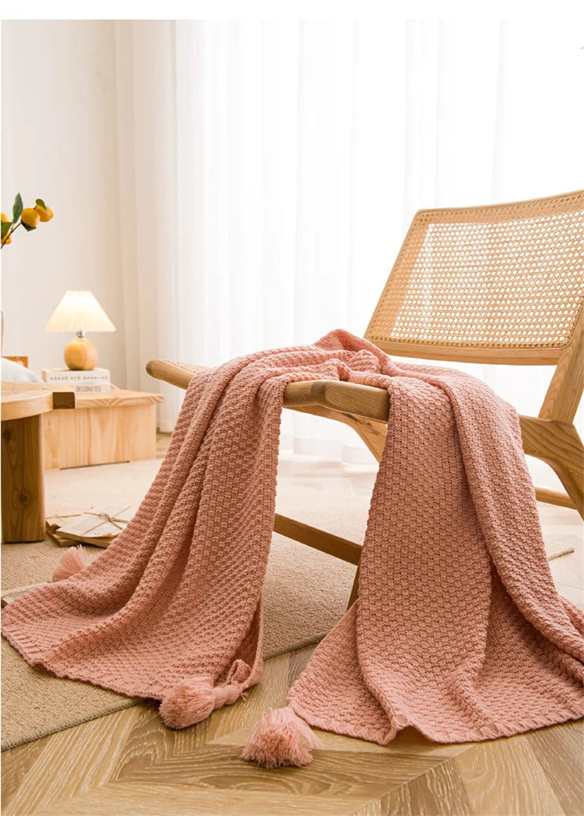 Image of the Soma Throw Blanket, featuring a cozy, soft fleece and cotton blend with a waffled texture. Available in various colorways and three sizes, this throw blanket has elegant tasseled corners and a knitted design, perfect for home décor enthusiasts looking to add comfort and style to their living space.