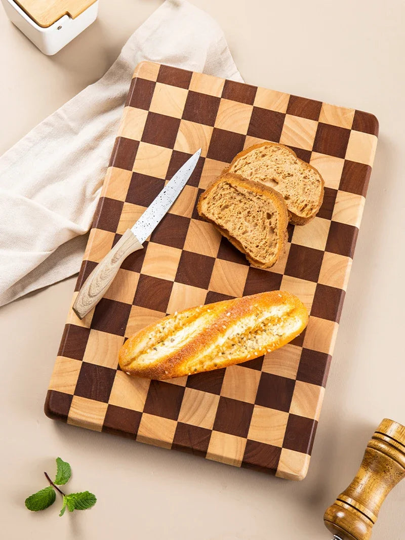 Rectangular wooden cutting board with a checkerboard pattern, available in three sizes. Features rounded corners and non-slip rubber feet, used for both meal prep and serving as a cheese board or decorative kitchen display.