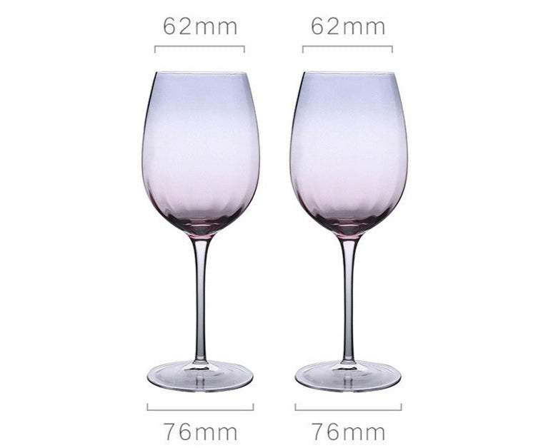 A collection of iridescent glassware from Domus Forge, featuring wine glasses, champagne coupes, decanters, and highball glasses in pastel gradient hues.