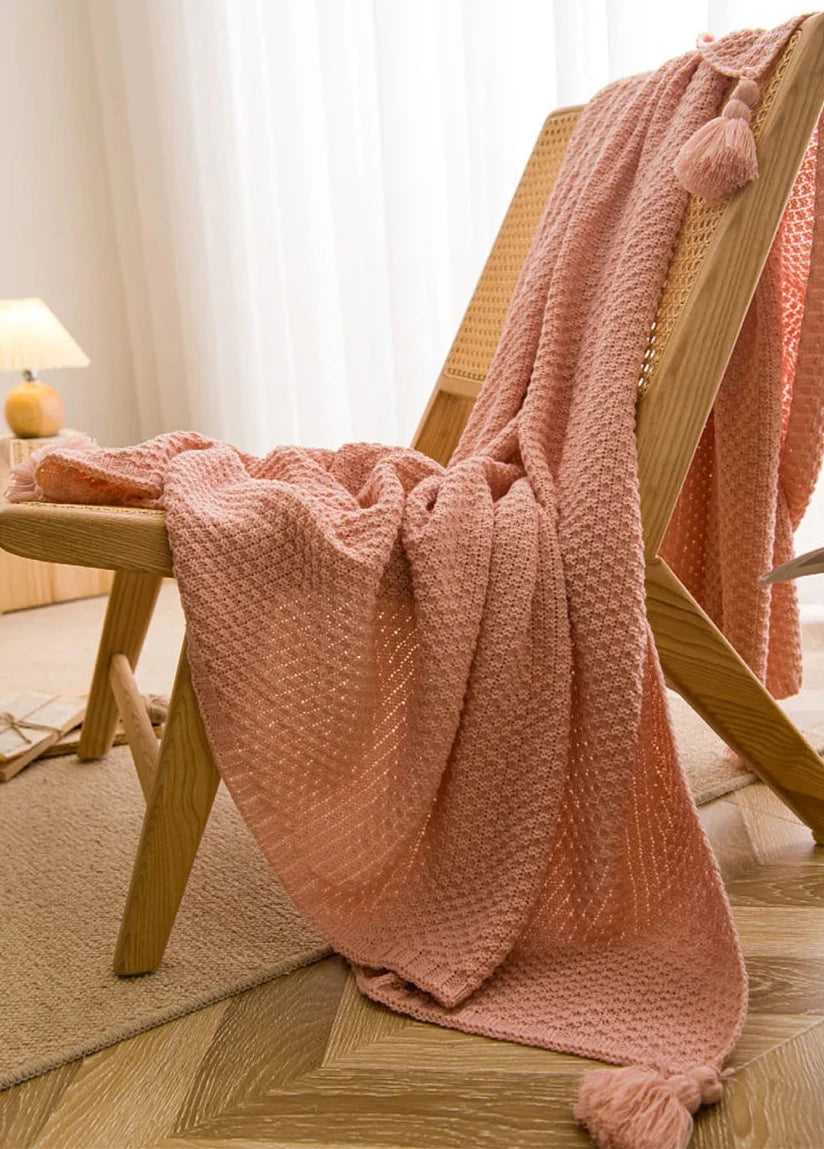 Image of the Soma Throw Blanket, featuring a cozy, soft fleece and cotton blend with a waffled texture. Available in various colorways and three sizes, this throw blanket has elegant tasseled corners and a knitted design, perfect for home décor enthusiasts looking to add comfort and style to their living space.
