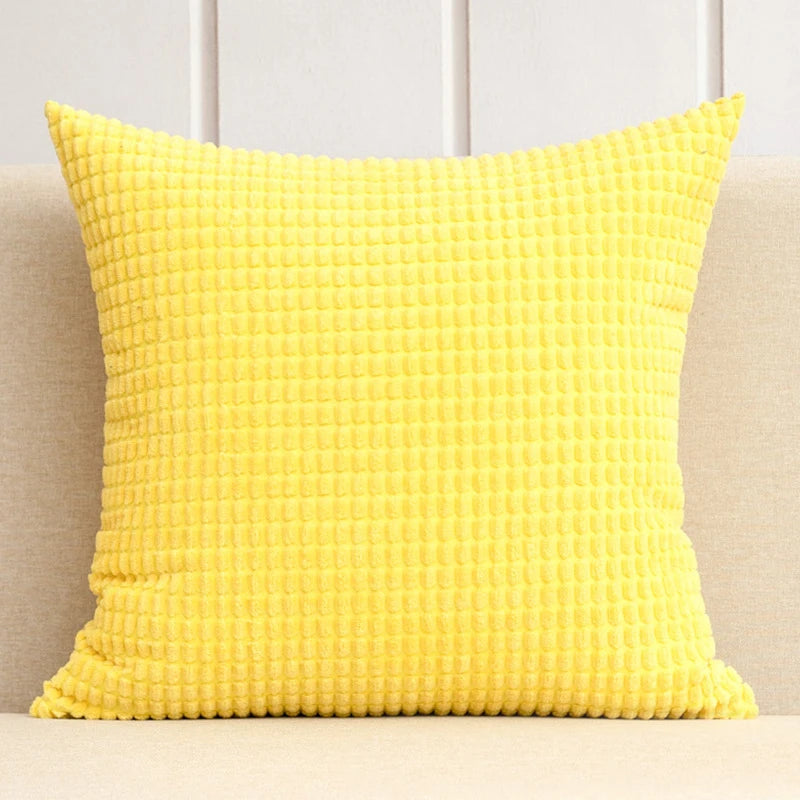 A stylish Warren Pillow Cover displayed on a couch, showcasing its soft corduroy corn grain texture. Available in various colorways and sizes, this square pillow cover adds warmth and elegance to any space. Ideal for home décor enthusiasts, it enhances living areas with a cozy, inviting touch. Please note that the pillow insert is not included.