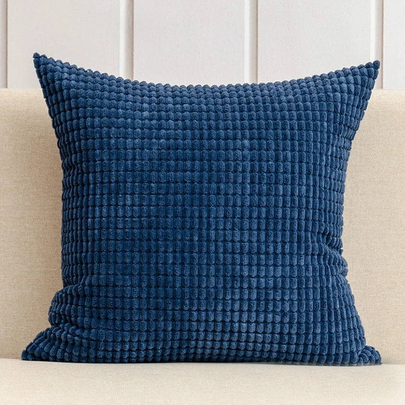 A stylish Warren Pillow Cover displayed on a couch, showcasing its soft corduroy corn grain texture. Available in various colorways and sizes, this square pillow cover adds warmth and elegance to any space. Ideal for home décor enthusiasts, it enhances living areas with a cozy, inviting touch. Please note that the pillow insert is not included.