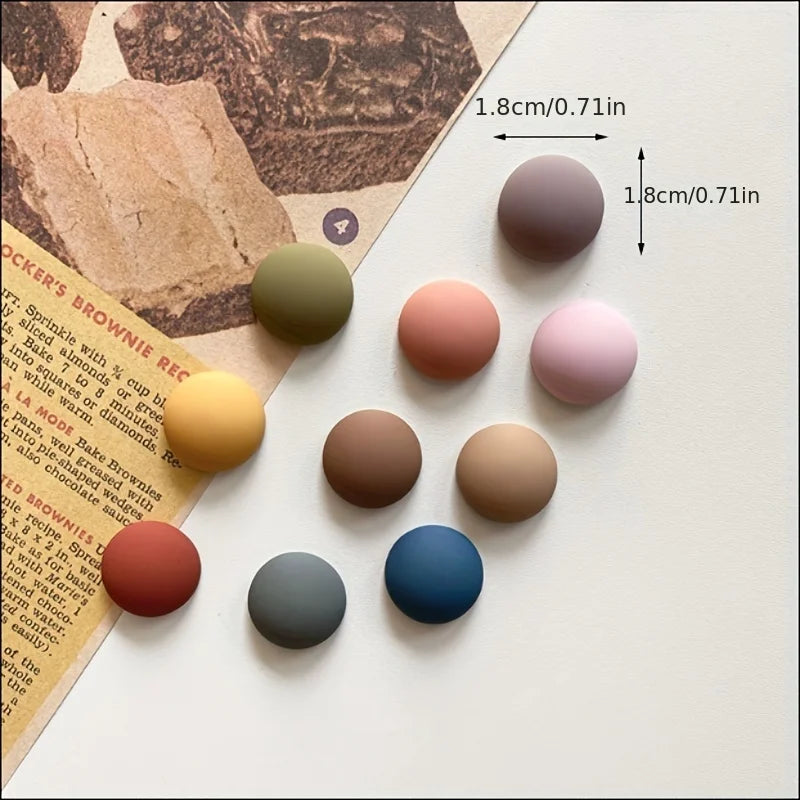 Image of the Dorina Magnets, featuring a set of 10 circular magnets in random vibrant colors. Each magnet measures 1.8 cm in diameter and is ideal for use in kitchens or offices, perfect for securing notes, lists, and reminders to metallic surfaces. A stylish and functional accessory for organizing spaces.