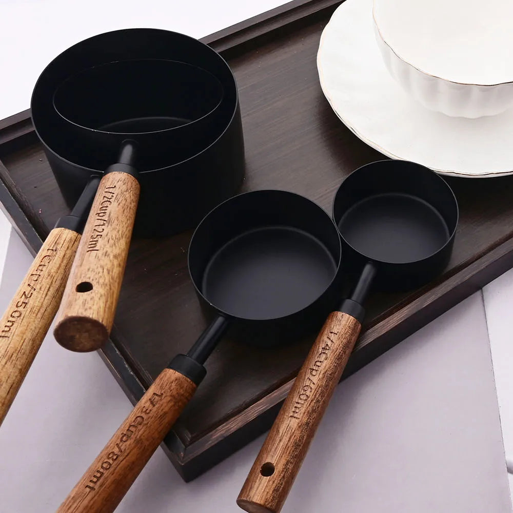 Stylish Lydia Measuring Cup & Spoon Set with wooden handles and stainless steel in black or gold, 8-piece set with engraved sizes for precise measurements, perfect for home décor enthusiasts and functional kitchen style.