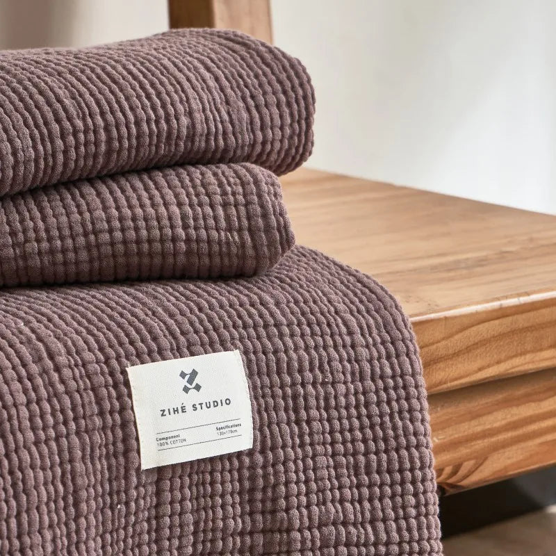 Nogu Throw Blanket – soft Maillard cotton throw with a layered gauze texture, fringe detail, and chic muted colorways, available in two sizes for cozy, stylish comfort.