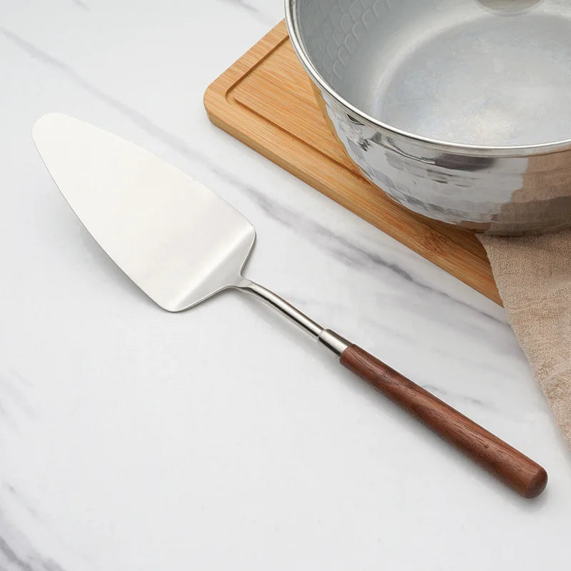 Wanda Serving Set – modern stainless steel serveware with elegant walnut handles, including a cake knife, cake shovel, serving spoon, ladle, and slotted turner for effortless entertaining.