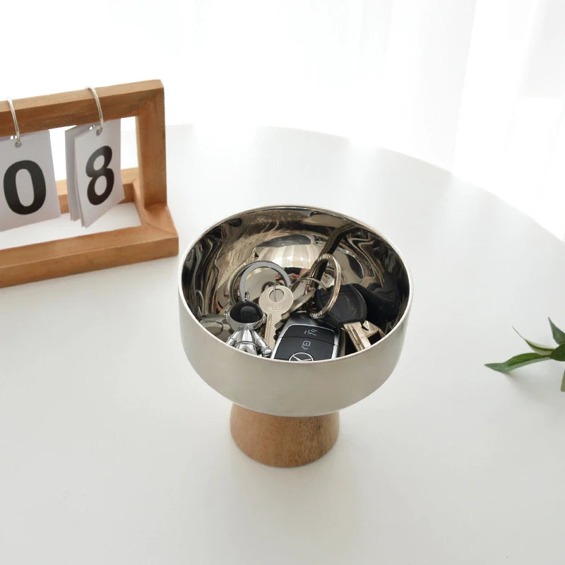 Eddard Serving Bowl featuring a modern design with a sleek stainless steel bowl and a sturdy wooden base. Compact and stylish, this small serving bowl is perfect for home decor enthusiasts looking to add a chic touch to their kitchen or coffee table. Ideal for serving snacks, fruits, or side dishes.