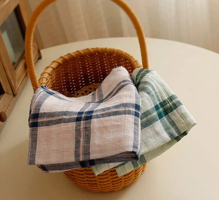 A set of large-format Veda Napkins measuring 40 x 60 cm, displayed in a classic plaid pattern with four neutral color options. The napkins are crafted from a durable cotton-linen blend, providing a textured, visually interesting look. Ideal for home décor enthusiasts, these versatile napkins add charm to any table setting.