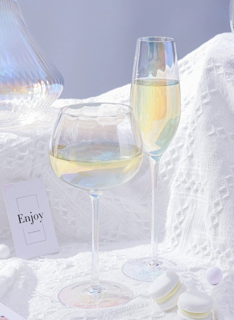 A collection of iridescent glassware from Domus Forge, featuring wine glasses, champagne coupes, decanters, and highball glasses in pastel gradient hues.