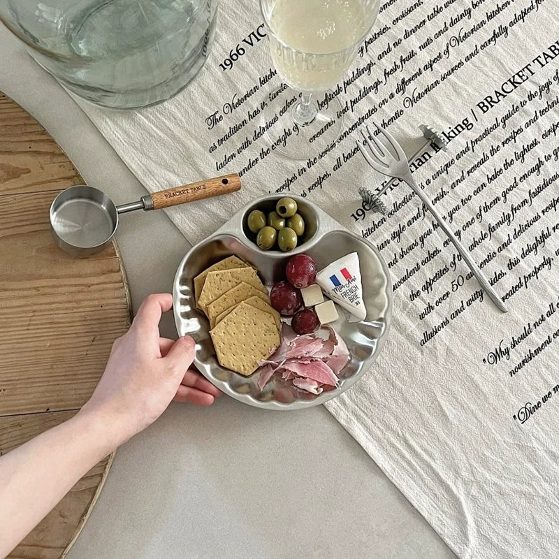 Elegant stainless steel Isadore Shell Tray with a unique shell design, featuring big and small sections for serving snacks, appetizers, or desserts. Perfect for entertaining, tableware with a vintage feel, and hosting in style. Compact yet versatile silver tray ideal for modern and sophisticated dining setups.