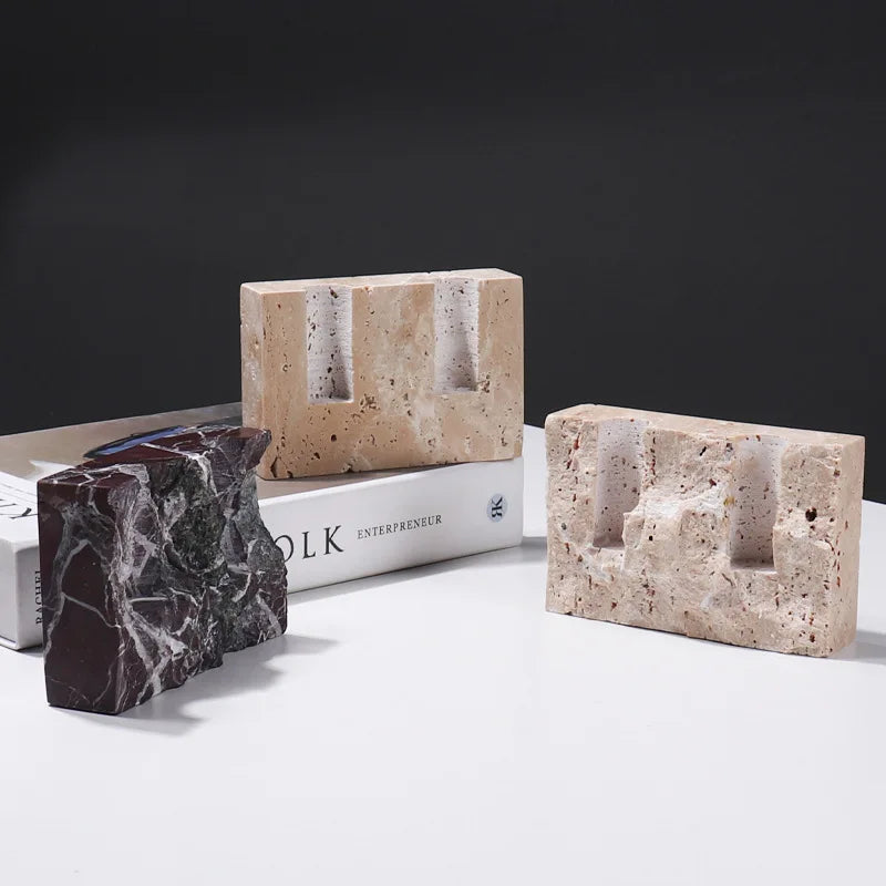 Brutalist candle holder with marble or travertine, anti-slip padding for stability.