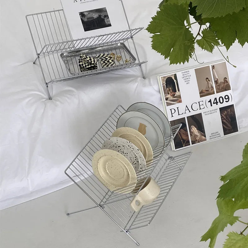 Image of the Elli Rack, a versatile Stainless Steel Magazine and Kitchen Rack in a sleek silver finish. Modern, simple design suitable for various uses in the kitchen or living spaces, adding contemporary elegance to your home.