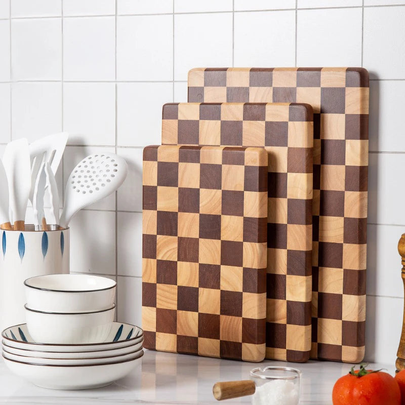 Rectangular wooden cutting board with a checkerboard pattern, available in three sizes. Features rounded corners and non-slip rubber feet, used for both meal prep and serving as a cheese board or decorative kitchen display.