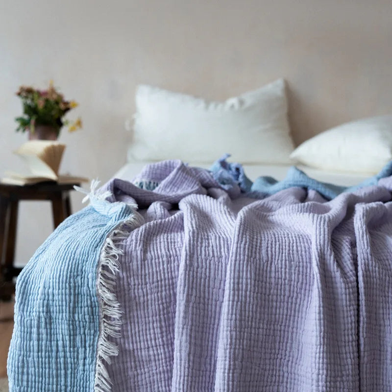 Nogu Throw Blanket – soft Maillard cotton throw with a layered gauze texture, fringe detail, and chic muted colorways, available in two sizes for cozy, stylish comfort.