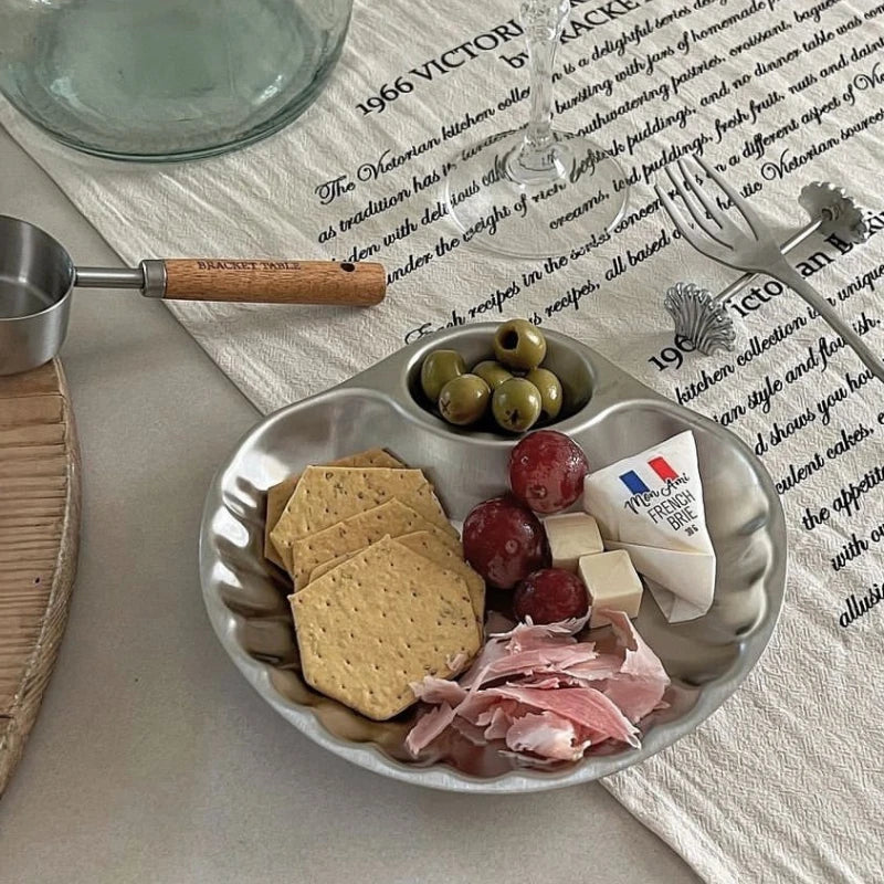 Elegant stainless steel Isadore Shell Tray with a unique shell design, featuring big and small sections for serving snacks, appetizers, or desserts. Perfect for entertaining, tableware with a vintage feel, and hosting in style. Compact yet versatile silver tray ideal for modern and sophisticated dining setups.
