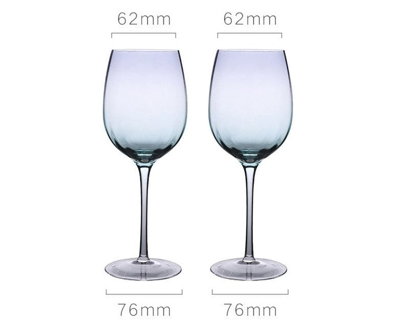 A collection of iridescent glassware from Domus Forge, featuring wine glasses, champagne coupes, decanters, and highball glasses in pastel gradient hues.