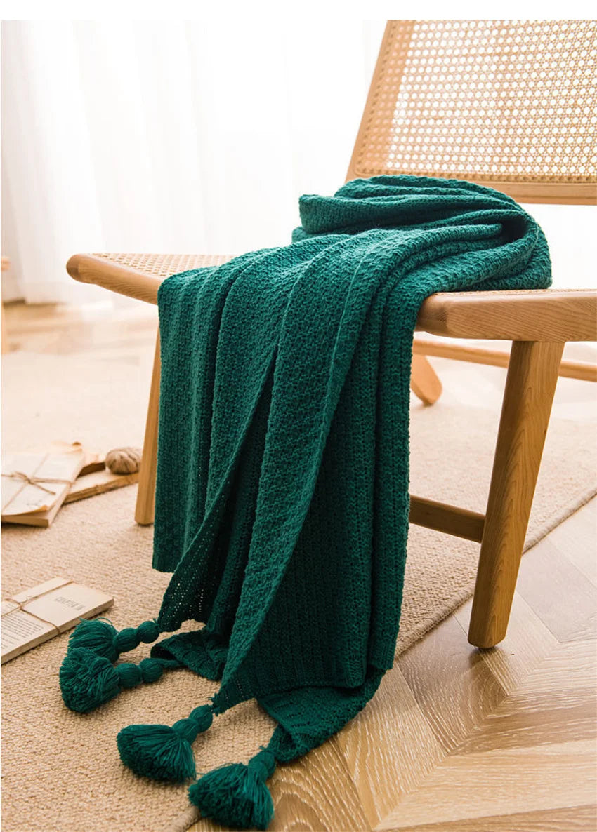 Image of the Soma Throw Blanket, featuring a cozy, soft fleece and cotton blend with a waffled texture. Available in various colorways and three sizes, this throw blanket has elegant tasseled corners and a knitted design, perfect for home décor enthusiasts looking to add comfort and style to their living space.