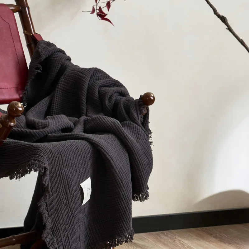 Nogu Throw Blanket – soft Maillard cotton throw with a layered gauze texture, fringe detail, and chic muted colorways, available in two sizes for cozy, stylish comfort.