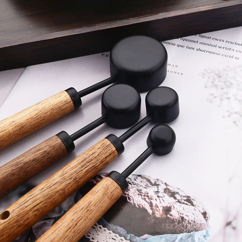 Stylish Lydia Measuring Cup & Spoon Set with wooden handles and stainless steel in black or gold, 8-piece set with engraved sizes for precise measurements, perfect for home décor enthusiasts and functional kitchen style.