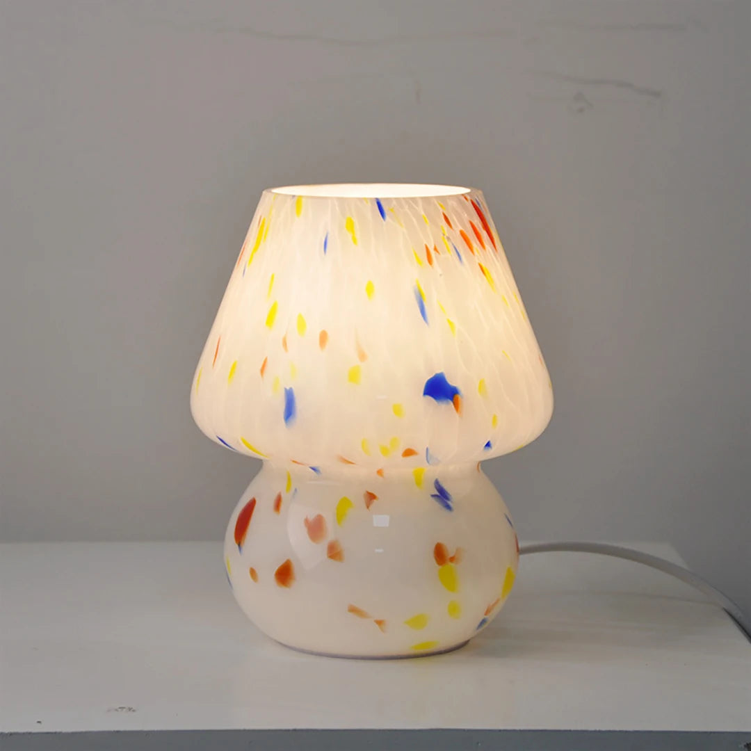 Carson Table Lamp – small mushroom-shaped glass lamp with a white base and colorful ink splat design, casting a soft, warm light for a playful and cozy ambiance.