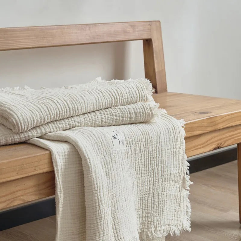 Nogu Throw Blanket – soft Maillard cotton throw with a layered gauze texture, fringe detail, and chic muted colorways, available in two sizes for cozy, stylish comfort.