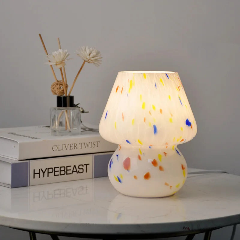 Carson Table Lamp – small mushroom-shaped glass lamp with a white base and colorful ink splat design, casting a soft, warm light for a playful and cozy ambiance.