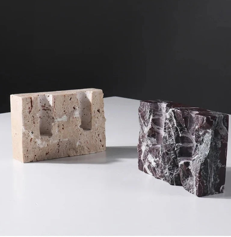 Brutalist candle holder with marble or travertine, anti-slip padding for stability.