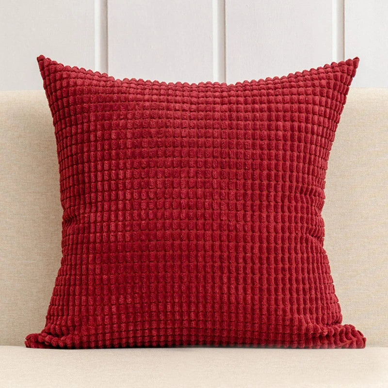 A stylish Warren Pillow Cover displayed on a couch, showcasing its soft corduroy corn grain texture. Available in various colorways and sizes, this square pillow cover adds warmth and elegance to any space. Ideal for home décor enthusiasts, it enhances living areas with a cozy, inviting touch. Please note that the pillow insert is not included.