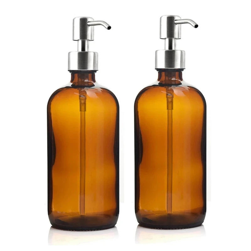 A set of two amber glass soap dispensers, each with a 16 oz capacity, featuring a choice of silver or black stainless steel pumps. Includes six printed labels for easy identification. Ideal for home décor enthusiasts, this reusable and refillable set adds a stylish touch to kitchens and bathrooms.