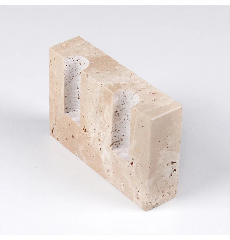 Brutalist candle holder with marble or travertine, anti-slip padding for stability.