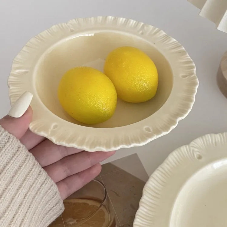 Damian Plate Collection – ceramic plates and bowls with delicate ruffled edges, available in white or cream, combining simple elegance with a soft, feminine touch.
