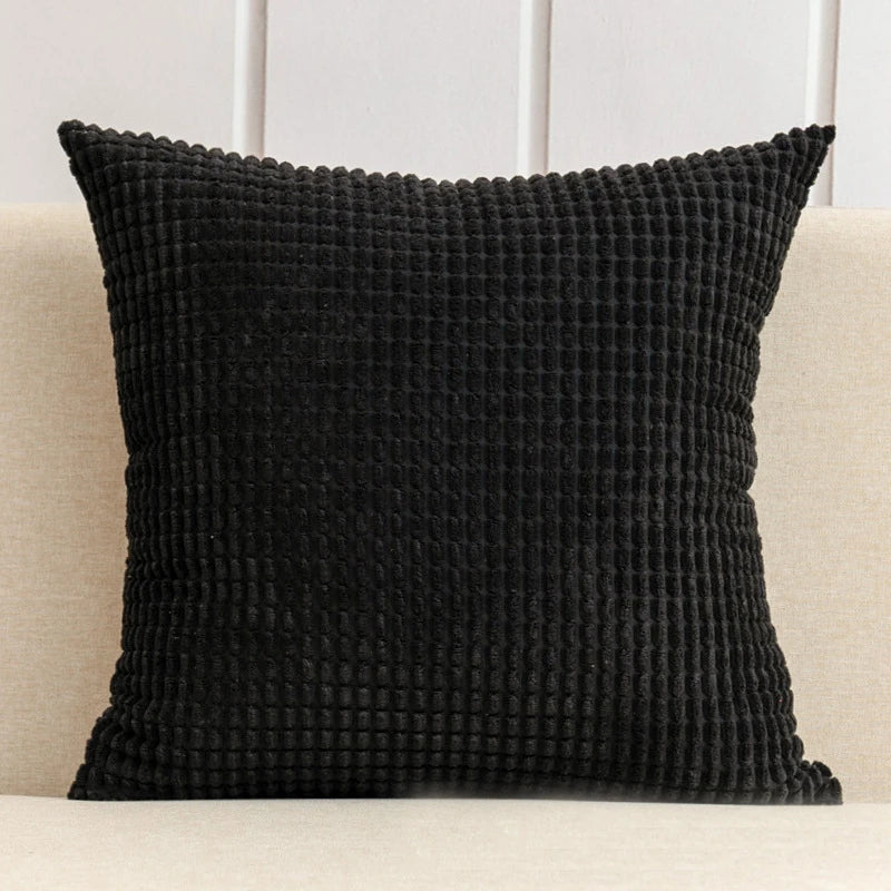 A stylish Warren Pillow Cover displayed on a couch, showcasing its soft corduroy corn grain texture. Available in various colorways and sizes, this square pillow cover adds warmth and elegance to any space. Ideal for home décor enthusiasts, it enhances living areas with a cozy, inviting touch. Please note that the pillow insert is not included.