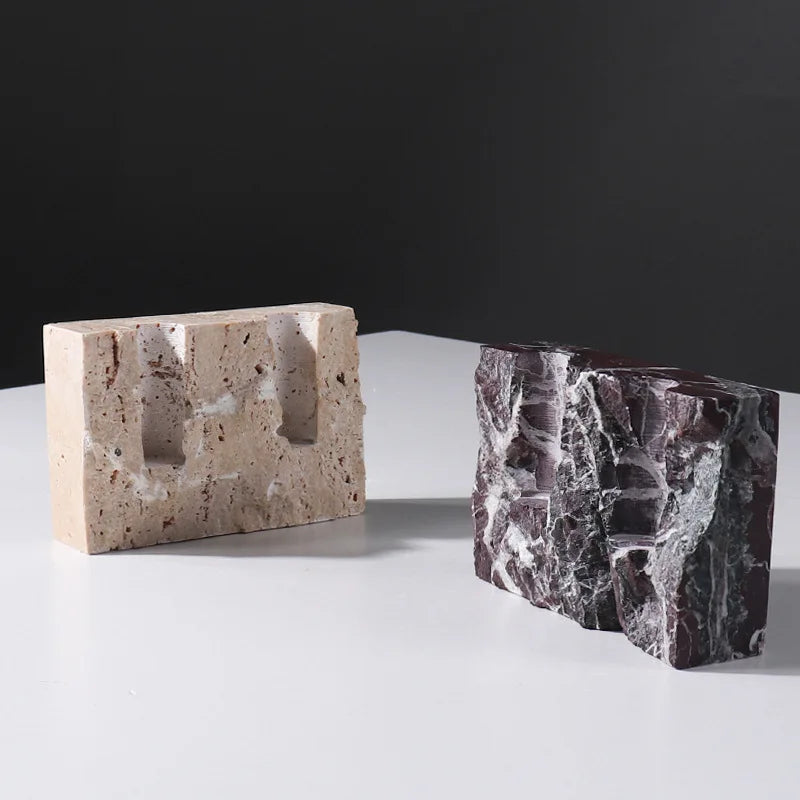 Brutalist candle holder with marble or travertine, anti-slip padding for stability.