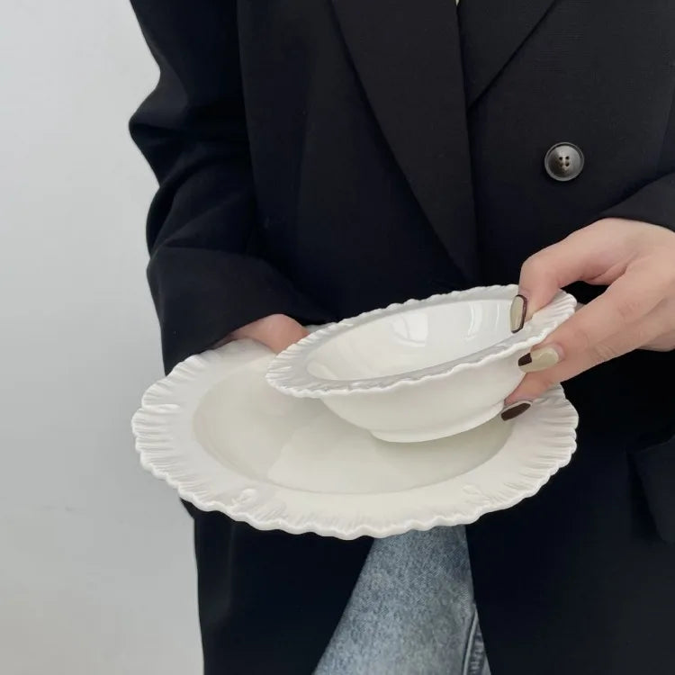 Damian Plate Collection – ceramic plates and bowls with delicate ruffled edges, available in white or cream, combining simple elegance with a soft, feminine touch.