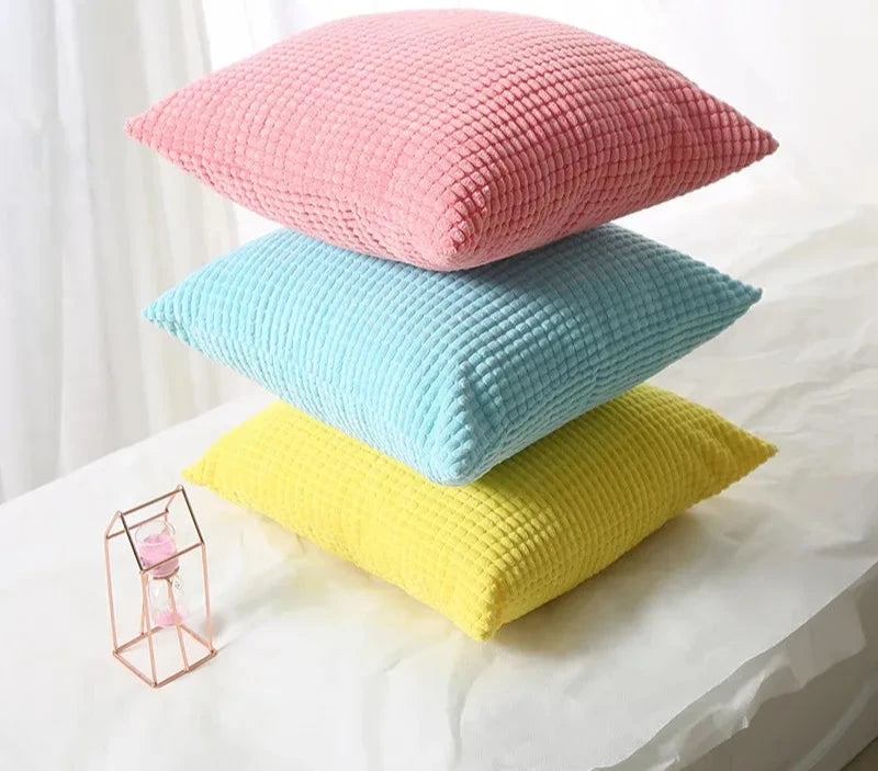 A stylish Warren Pillow Cover displayed on a couch, showcasing its soft corduroy corn grain texture. Available in various colorways and sizes, this square pillow cover adds warmth and elegance to any space. Ideal for home décor enthusiasts, it enhances living areas with a cozy, inviting touch. Please note that the pillow insert is not included.