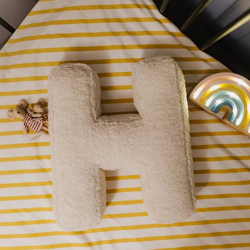 Yeats Throw Pillow – soft lambswool alphabet-shaped pillow in neutral beige, perfect for nurseries, playrooms, and kids' rooms as a cozy and educational accent.