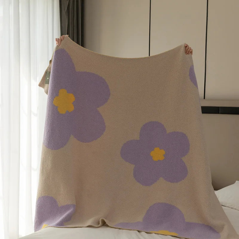 Micah Throw Blanket with large daisy print, available in small or standard size, four colorways, soft polyester/cotton blend, cozy and warm for home decor enthusiasts.