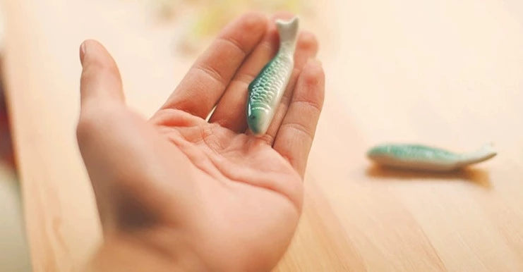 Zakka Chopstick Holder - Hand-painted porcelain fish in green and white ceramic. Perfect for hosting, intricate details, available as a single or pair. Small yet impactful dining accessory.