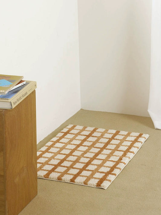 Modern checkered bath mat in warm colorways, striped design. Elevate your bathroom décor. 