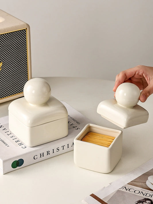 A set of ceramic decorative boxes in creamy tones with charming ball details. Versatile in styling, these boxes can be placed anywhere in the home, including the bathroom. Ideal for storing small keepsakes while adding a touch of timeless elegance to your décor.