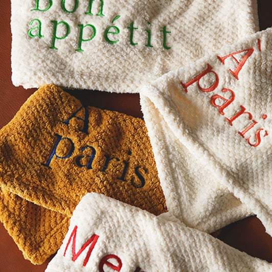 Charming Tal Kitchen Towels in four colorways with French texts embroidery, featuring a convenient hang loop. Soft and absorbent cotton for a delightful and efficient kitchen experience.