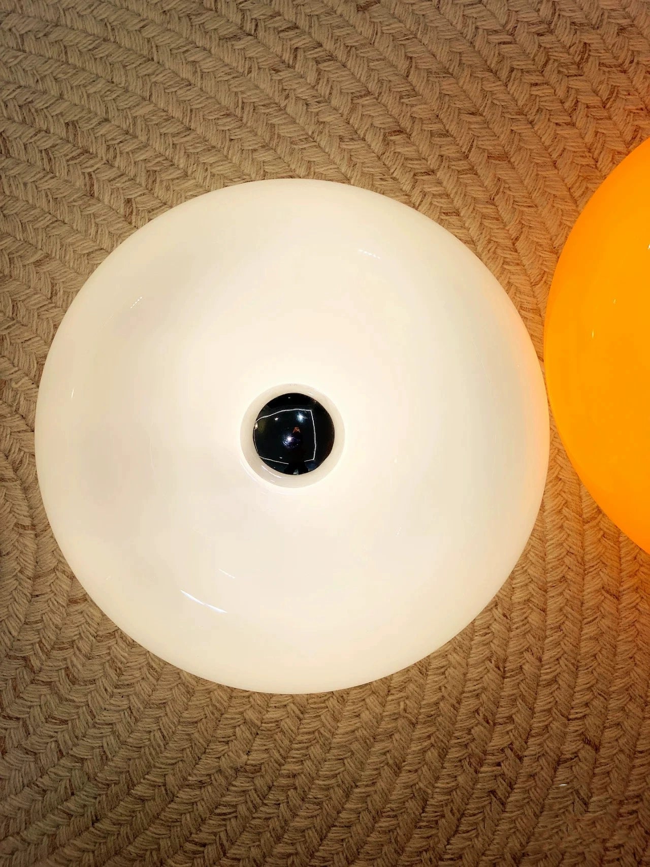 Orange or white doughnut-shaped Roman Lamp - a versatile modern masterpiece for table or wall placement. Glass design adds sophistication to contemporary decor. Illuminate your space with this chic statement piece.