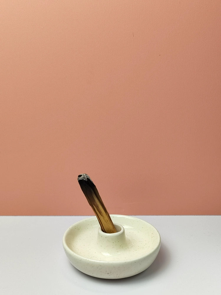 White ceramic Maeve Incense Holder with a dedicated burning plate for sage and palo santo. Elegant and purposeful, this accessory enhances the ritual of incense burning, creating a mystical ambiance in any space.