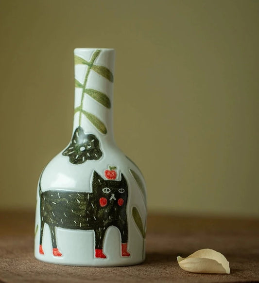 Hand-painted ceramic Kitty Kat Vase featuring a charming black cat design, perfect for showcasing a single rose or cutting. This small vase adds a whimsical touch to your decor and can be styled individually or grouped for an eclectic display. A unique and artistic expression for any room.