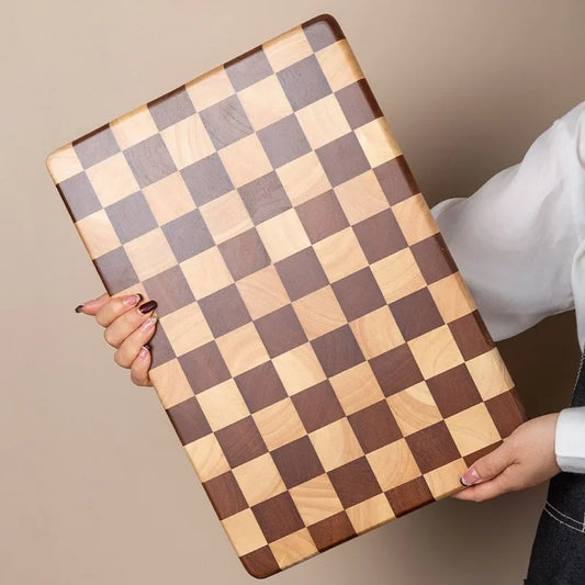 Rectangular wooden cutting board with a checkerboard pattern, available in three sizes. Features rounded corners and non-slip rubber feet, used for both meal prep and serving as a cheese board or decorative kitchen display.